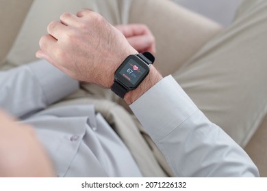 Hands of man looking at screen of smartwatch checking his heart rate - Powered by Shutterstock