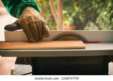 Hands Of A Man Making Custom Furniture Wood Parts On Machine Tool Called Table Saw In Woodworking Shop. Wood Production Concept. Detail