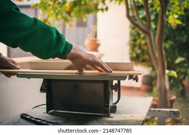 Hands Of A Man Making Custom Furniture Wood Parts On Machine Tool Called Table Saw In Woodworking Shop. Wood Production Concept. Detail