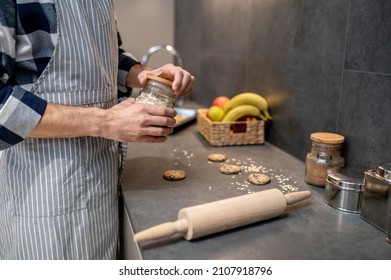 Hands Of Man In Opening Jar Of Almond Slices