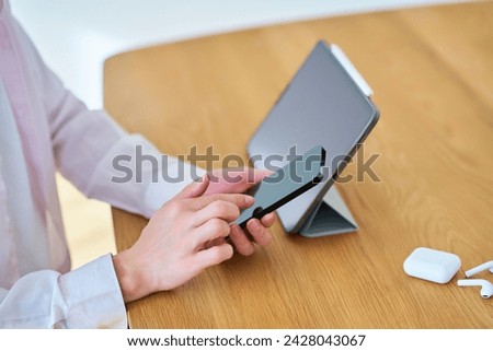 Hands of a man operating a tablet PC and smartphone