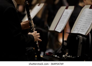 Hands of man playing the clarinet in the orchestra in dark colors - Shutterstock ID 364954769