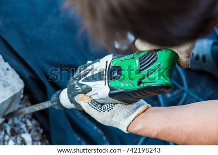 hands of a man with a portable jackhammer. the working process