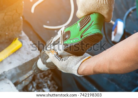 hands of a man with a portable jackhammer. the working process