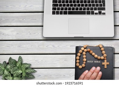 Hands of a man praying with bible and computer laptop, Religion concept