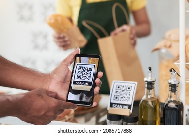 Hands Of Man Scanning QR Code With Smartphone To Get Bonuses When Buying Food In Cafe
