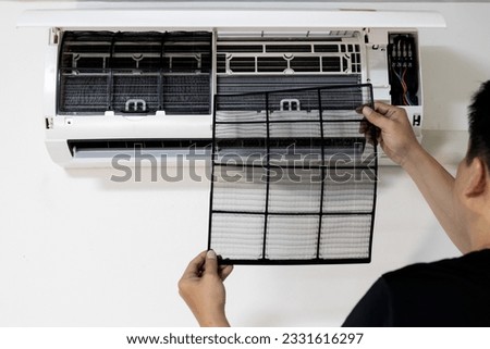 Hands of man showing air filter after cleaning the dirty clogged by himself at home,clean or replace the air conditioner filter to maintain optimal performance and air quality,prevent dust allergies