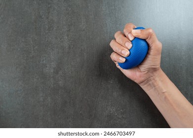 Hands of a man squeezing a stress ball on the table in the office - Powered by Shutterstock