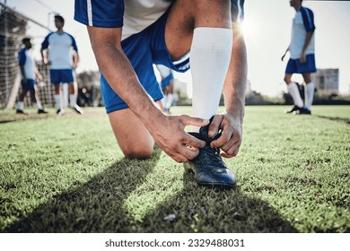 Hands, man and tie shoes on soccer field, prepare for training or fitness games. Closeup, football player or athlete getting ready with sneakers lace in sports, competition and contest on grass pitch - Powered by Shutterstock