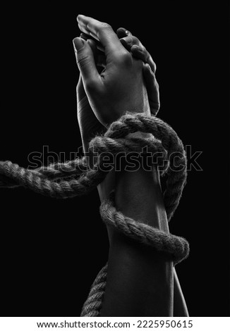 Hands of a man with hands tied with ropes. Photo black and white