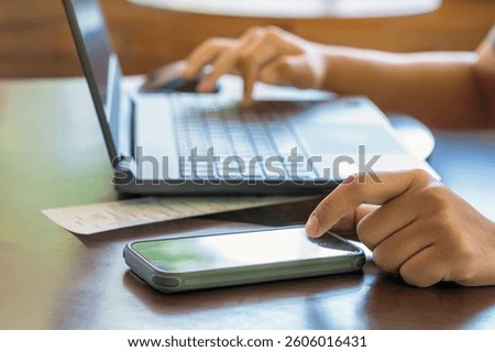 Hands of man using mobile smart phone and laptop with internet. Technology Connection and social media. Business and man with cellphone, typing and laptop. Work on computer and cellphone in workplace.