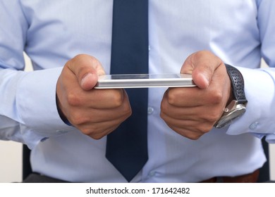 Hands of a man using a smartphone.