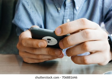 Hands of a man using a smartphone.