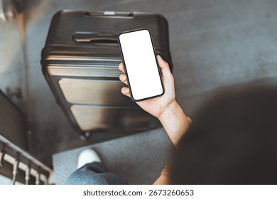 Hands of man using smartphone with white blank screen mockup in airport terminal, Traveler with phone with suitcase, copy space for advertising.