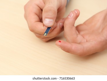 Hands Of Man Using Test Strip For Blood Sugar Monitoring. Diabetes Concept