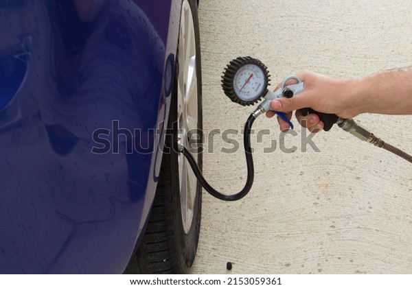 Hands of a\
man who checks the pressure of the car tires with a pressure gauge.\
With correct pressure you can save\
fuel