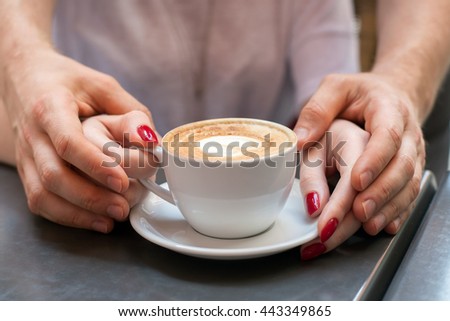 Hands of a man and a woman and coffee cup 