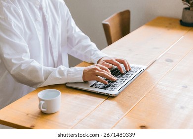 Hands of a man working at a table (telework, remote work, working from home,
