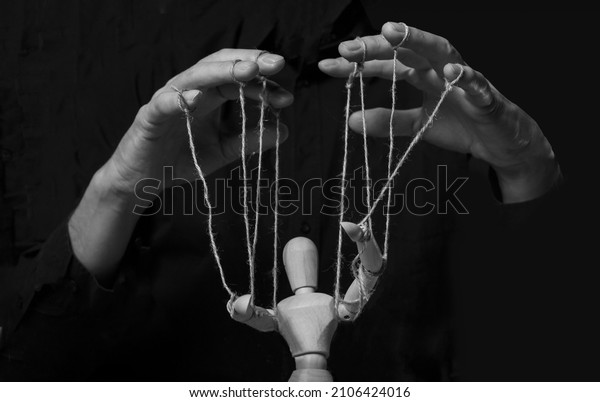 Hands manipulating puppet. Master of marionette\
in action.