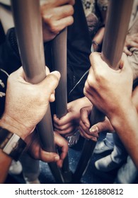 The hands of many passengers are holding handrail in the subway, indicating a crowded civilization.