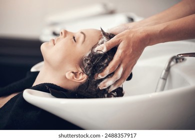 Hands, massage and hairdresser with client in spa, relax and basin for wash and treatment. Soap, salon and hairstyle or cleaning for happy customer person, keratin or scalp shampoo for hair care