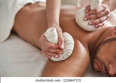 hands massage man's back in wellness salon