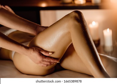 Hands of the massage therapist in the spa salon make massage to a young unidentified woman. Concept of care and beauty. Massage of buttocks, prevention of cellulitis
