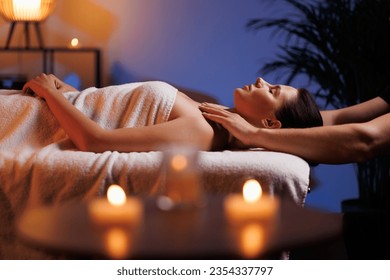 The hands of a masseuse make a manual massage of the head of a beautiful female client. The concept of scalp treatment and hair growth stimulation. - Powered by Shutterstock