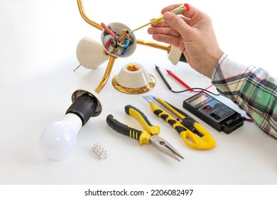 hands of the master repairing the disassembled chandelier - Shutterstock ID 2206082497