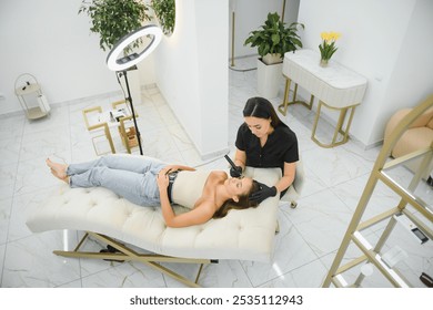 hands of the master who performs the procedure of permanent makeup of eyebrows view from above. Permanent eyebrow makeup PMU for brunettes.