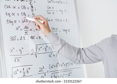 Hands of math teacher circling variable in formula on whiteboard with red highlighter when explaining topic to students - Powered by Shutterstock - Get 15% off with code: PIKWIZARD15