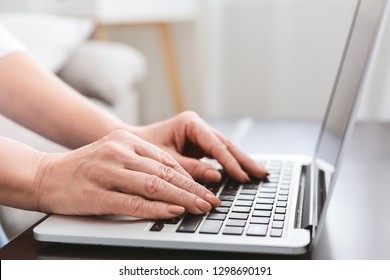 Hands Of Mature Woman Working On Laptop Computer At Home, Typing Something, Closeup