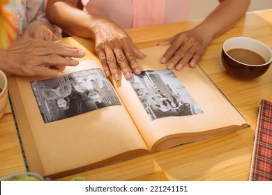 Hands of mature women watching old photos in the - Shutterstock ID 221241151