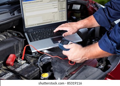 Hands of mechanic working in auto repair shop.