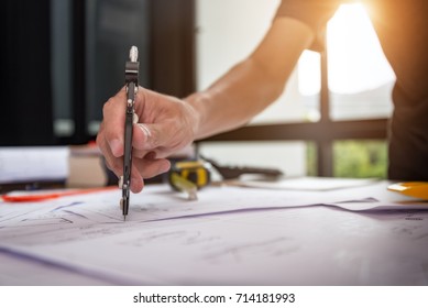 Hands Of A Mechanical Engineer Are Holding A Compasses For Writing To Work. Engineering Tools And Construction Concept.