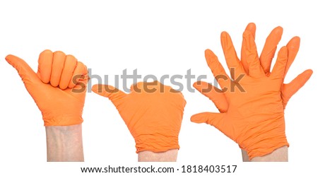 Hands of a medic wearing a orange latex gloves. Medical gloves. Surgical glove. Covid-19 prevention concept.