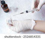 Hands in medical gloves remove cap from syringe needle. Opening syringe. Routine vaccinations for children concept. Vaccination. Sterile medical items. Open syringe needle for injection. Antibiotics.