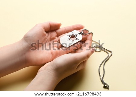 Hands with military tag of Israeli soldier on color background