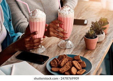 Hands, milkshake and women relax at cafe outdoor for healthy drink, bonding and eating cookies on lunch date. People, smooth and food with phone, breakfast or ice cream dessert together at restaurant - Powered by Shutterstock