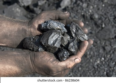 Hands of the miner with coal