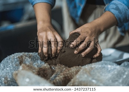 Hands molding clay in a clay workshop to teach people how to mold the material to create figures.