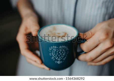 In the hands of a morning cup of coffee in blue
