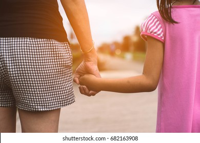 Hands of mother and daughter.