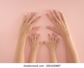 hands of mother and daughter with colorful nails on the pastel pink background. summer modern tropical abstract art with female hand. minimal modern background parenting idea. - Powered by Shutterstock