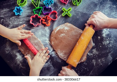 Hands of mother and daughter using rolling pins together in the kitchen. Mother teaching daughter how to bake cookies for holidays. Easter baking preparation. Easter food concept. Top view. - Powered by Shutterstock