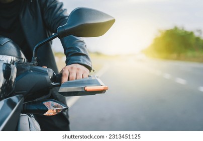 Hands of a motorcyclist on the handlebars on the road. Close up of hands of biker on the handlebars of a motorcycle outdoors. Motorbike speeding concept