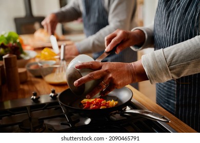 Hands of multi-cultural elderly couple cooking healthy breakfast together in modern kitchen at stove. - Powered by Shutterstock