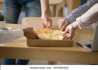 Hands Of Multiracial People Taking Cheese And Ham Pizza Slices From Box On Work Desk, Employees Eat Lunch Meal Together Enjoy Italian Food At Workplace, Office Delivery Service Concept, Close Up View