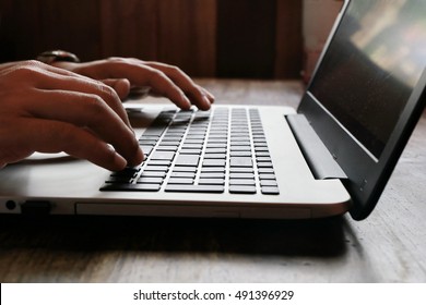 Hands multitasking man working on laptop connecting wifi internet, businessman hand busy using laptop at office desk, finger typing on keyboard laptop computer sitting at wooden table,work at home.