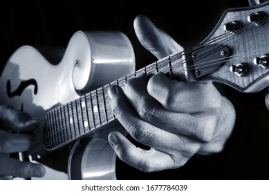 hands of musician playing traditional bluegrass mandolin, blue image